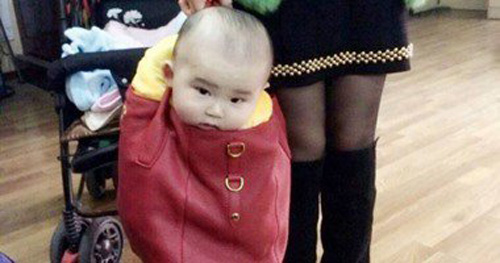 أم صينية تحمل طفلها فى حقيبة يدها تثير غضب مستخدمى الإنترنت