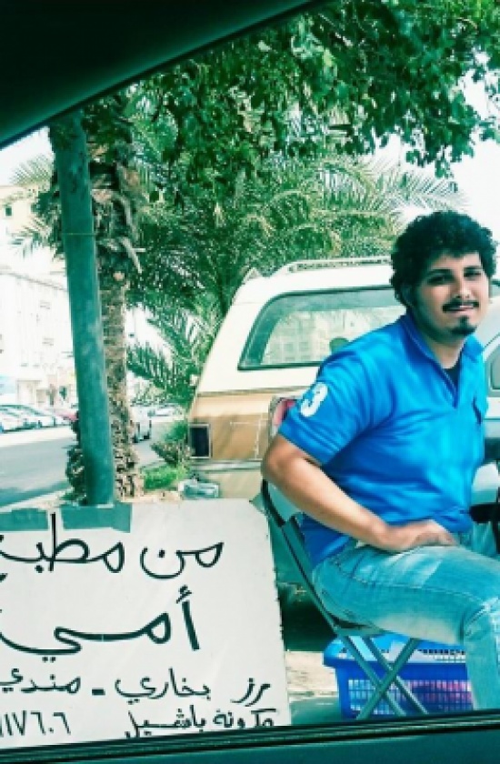 شاب سعودي يبيع "رزاً ودجاجاً" على الطريق معلقاً لافتة "من مطبخ أمي" شاب سعودي يبيع "رزاً ودجاجاً" على الطريق معلقاً لافتة "من مطبخ أمي"