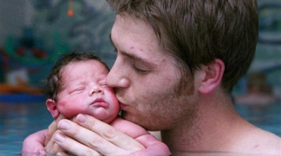 أب بريطاني يعلم ابنه السباحة بعد يوم واحد فقط على ولادته