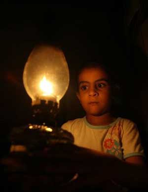 أطفال يدرسون على ضوء الشموع والقناديل بغزة