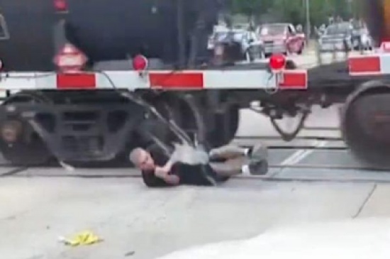 شاهد: رجل يخاطر بحياته ويعبر من تحت قطار متحرك