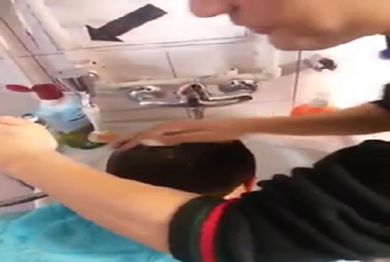 شاهد.. حلاق يبصق على رأس أحد الزبائن أثناء غسل شعره