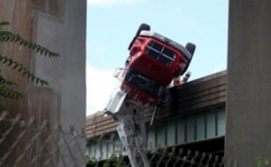 شاهد.. انقلاب شاحنة على جسر يتسبب بكارثة