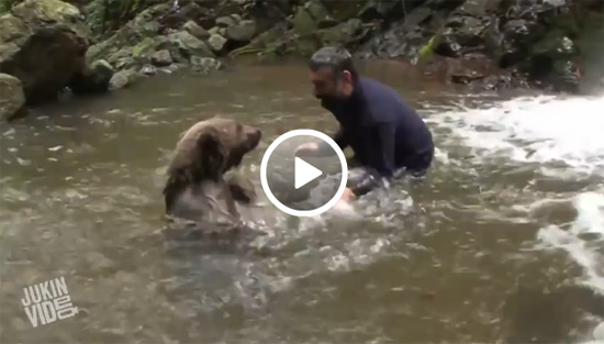 بالفيديو.. رجل يلعب مع دب في أحد الأنهار