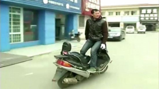 صيني يقود دراجته النارية بطريقة خاصة