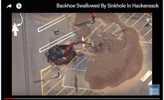 بالفيديو : حفار يسقط في حفرة وسط الطريق