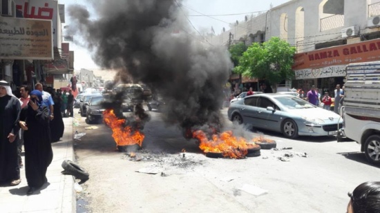 عمال وطن في الطفيلة يغلقون طريقاً بالاطارات المشتعلة احتجاجاً