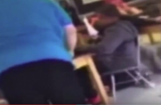 شاهد..  معلم يسحب الكرسي من تحت أحد الطلاب ويسقطه أرضاً