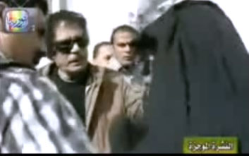 القذافي يكشف نقاب امرأة ليبية
