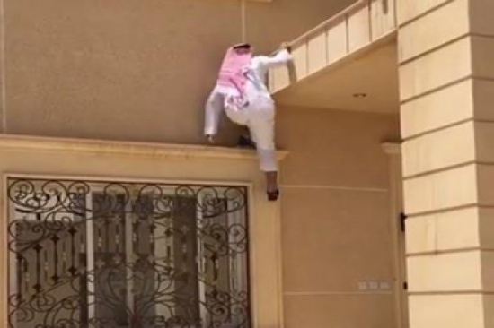 شاهد..  شاب بثوب وشماع يتسلق طابقين في ثوان