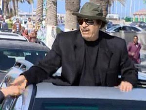 القذافي يظهر في سيارة مكشوفة بطرابلس مرتديا قبعة خضراء