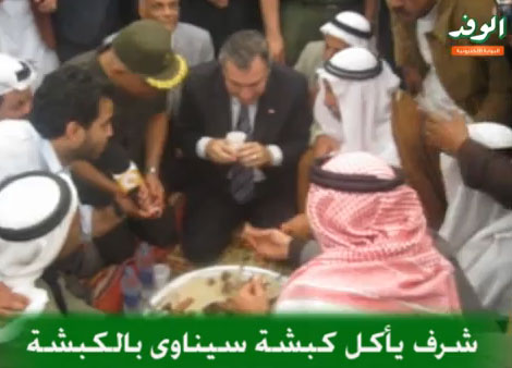 عصام شرف جالسا على الأرض.. يأكل بيديه.. ويحتسي مع بدو سيناء الشاي