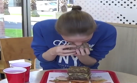 بالفيديو: فتاة حسناء تخوض تحدي تناول ساندوتش برجر من تسع طبقات