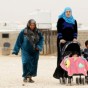 لاجئات سوريات يسرن بصحبة أطفال بمخيم الزعتري للاجئين السوريين - ارشيفية