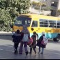 طلبة إحدى المدارس الخاصة يعبرون الشارع لركوب باص مدرسة خاصة