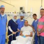 عامر شفيع على سرير الشفاء مع الطاقم الطبي الذي أجرى العملية والى جانبهم أسامة طلال