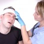 ممرضة تعالج رأس رجل تلقى ضربة - تعبيرية