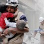 مسعفان يحملان أطفالا في منطقة تعرضت للقصف في حلب - ارشيف