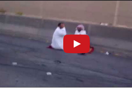 شابان يفترشان الطريق بانتظار المرور بعد تعرضهم لحادث تصادم