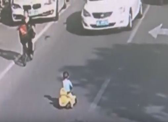 بالفيديو: لحظة إنقاذ شرطي لطفل علق وسط شارع مزدحم