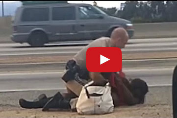 شرطي يعتدي على امرأة في وسط طريق