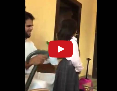 يسرح شعر ابنته بواسطة مكنسة كهربائية