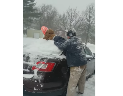 أب يستخدم ابنه كممسحة لتنظيف الثلج من سيارته (فيديو)