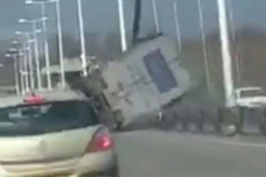 شاهد.. انقلاب شاحنة على جسر مرتفع بفعل الرياح