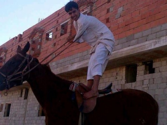 شاب بلا ذراعين  يستخدم قدميه في ممارسة حياته الطبيعة