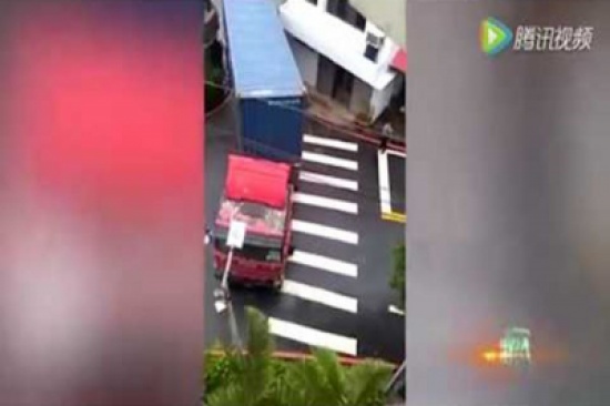 شاهد..  سائق ماهر يعبر بشاحنته فتحة ضيقة بين مبنيين