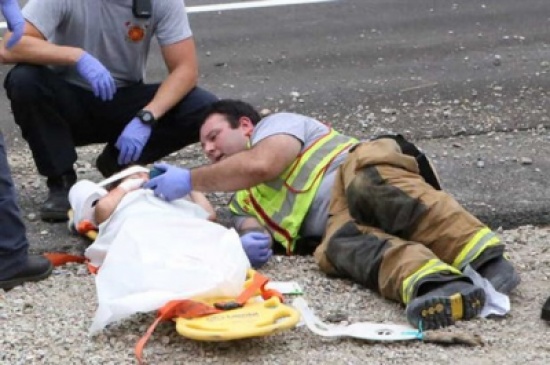 رجل مطافئ يهدئ من روع طفل صغير تعرض لحادث رجل مطافئ يهدئ من روع طفل صغير تعرض لحادث