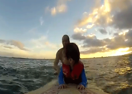 أب يعلم ابنه ذا الثلاث سنوات ركوب الأمواج