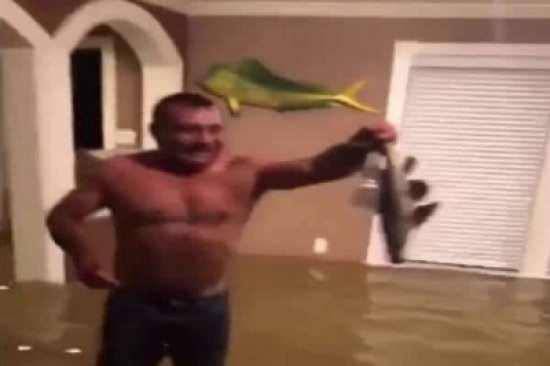 بالفيديو: اصطاد سمكة في غرفة منزله بعدما غمرتها مياه الفيضانات
