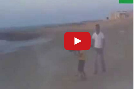 رجلين يعلمان طفلا ليبيا على استخدام الـ "آر بي جي"