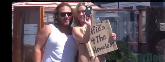 بالصور.. فتاة تلتقط "سيلفي" مع المارة بالبكيني لجمع أموال للمشردين