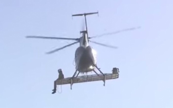 رجل يجلس على جناح مروحية لإنقاذ طائر