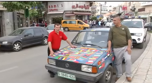 بالفيديو.. فلسطينى يغطى سيارته بأعلام الدول المعترفة ببلاده
