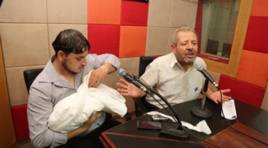 بالصور: فلسطيني يدخل الإذاعة حاملاً جثمان طفلته