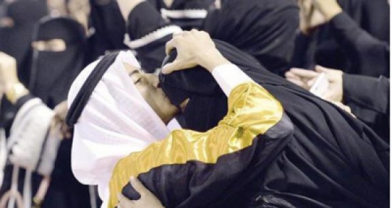 صورة: شاب يقبل جبين والدته ويلبسها عقاله في حفل تخرجه من الجامعة صورة: شاب يقبل جبين والدته ويلبسها عقاله في حفل تخرجه من الجامعة