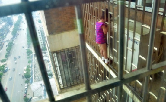 إنقاذ طفلة صينية علق رأسها بين قضبان الطابق الـ  24  " صور "