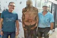 عامل مقبرة يلتقط صورة مع جثة رجل