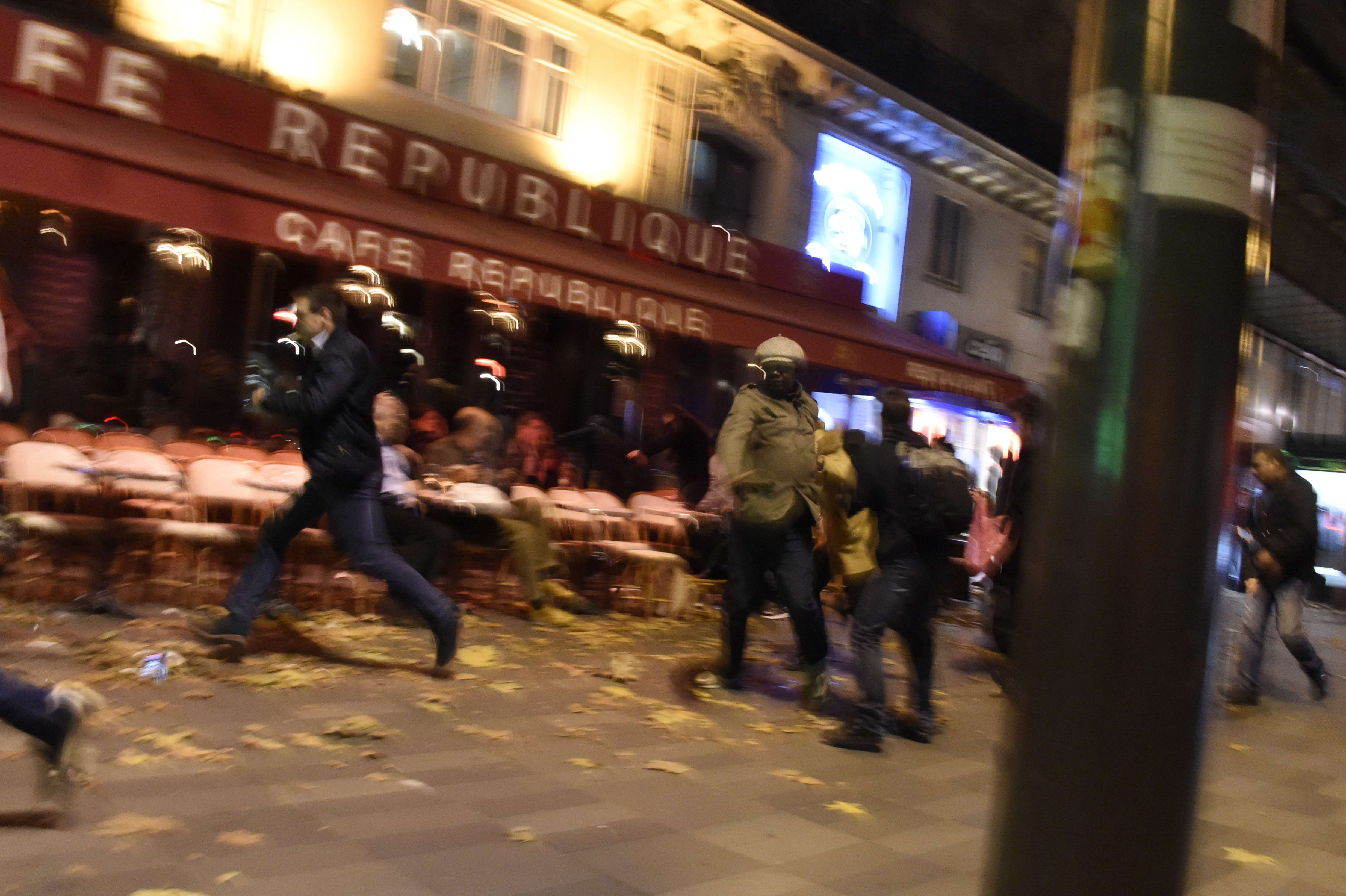 TOPSHOTS People run after hearing what is believed to be explosions or gun shots near Place de la Republique square in Paris on November 13, 2015. At least 18 people were killed in several shootings and explosions in Paris today, police said. AFP PHOTO / DOMINIQUE FAGET