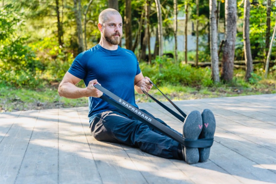 Styrketräning med Napraband powerbands — seated row utomhus