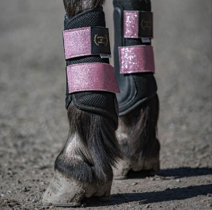 rosa glitterspännen på svarta benskydd till ponny