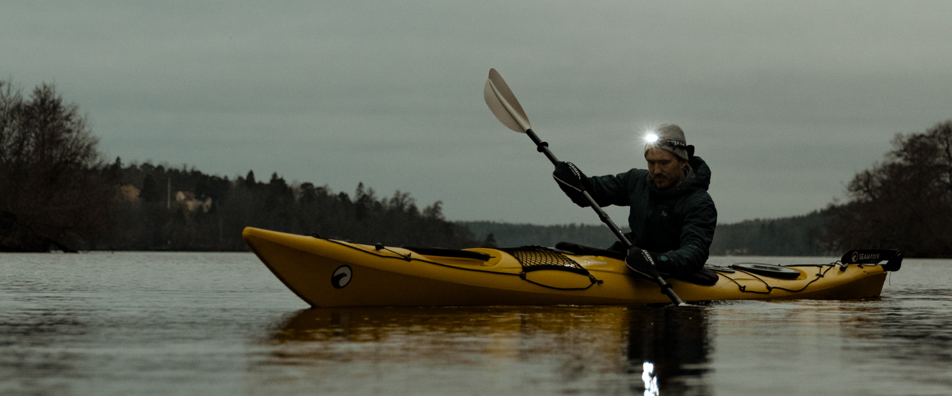 Paddlare på vattnet i kvällsljus
