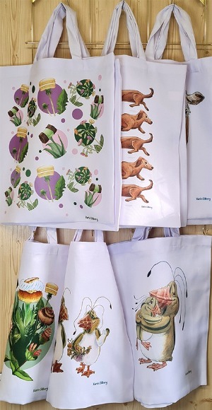 Foto på tygpåsar i butiken. Motiven på tygpåsarna är melonpingviner, kakblommor och taxar.