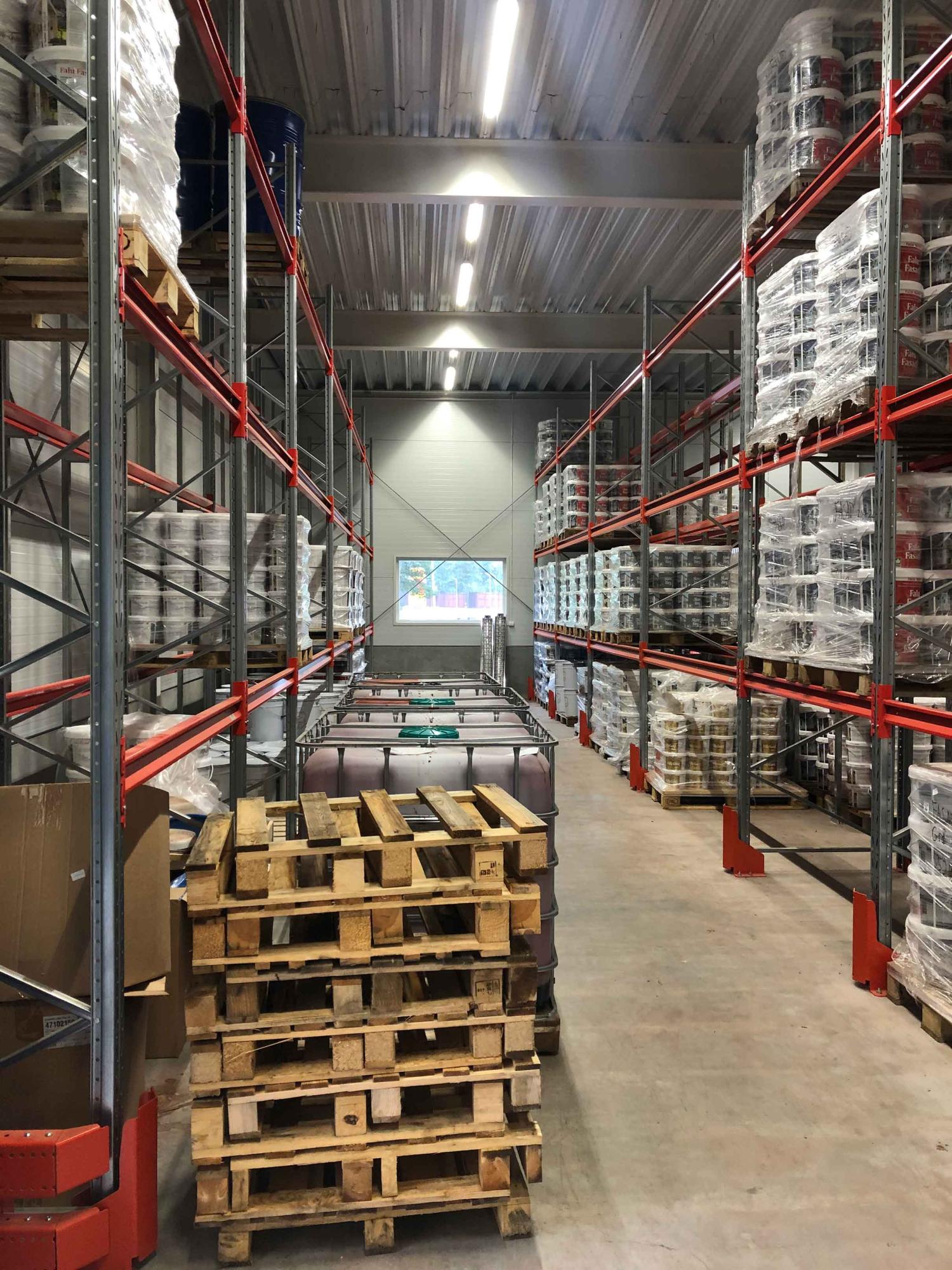 Lagergång med inplastade pallar och byggmaterial