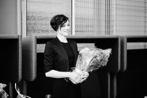 NIKO-projektin projektipäällikkö Minna Salakari kukkakimppu kädessään väitöstilaisuuden jälkeen.