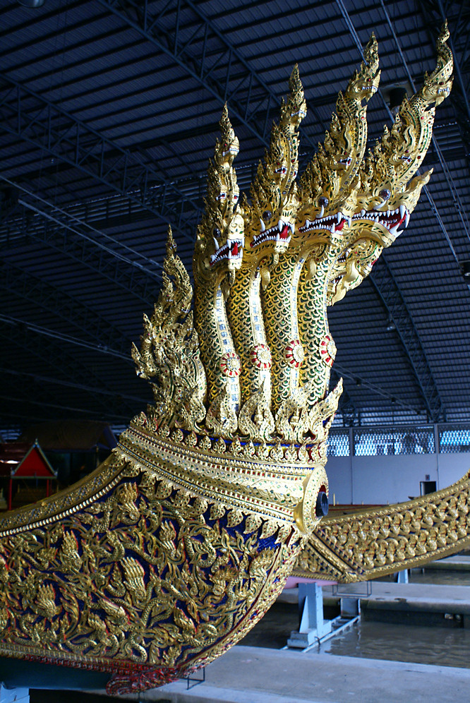 The royal barge with a seven-headed golden Naga sprouting from the bow is called the the Anantanakharat. Notice it also has bow gun poking out. Thai seven-headed golden Naga boat
