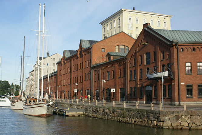 Old Helsinki harbour warehouses now turned into resturants for sightseeing tourists who need to read their travel guide whilst drinking a beer Helsinki harbour